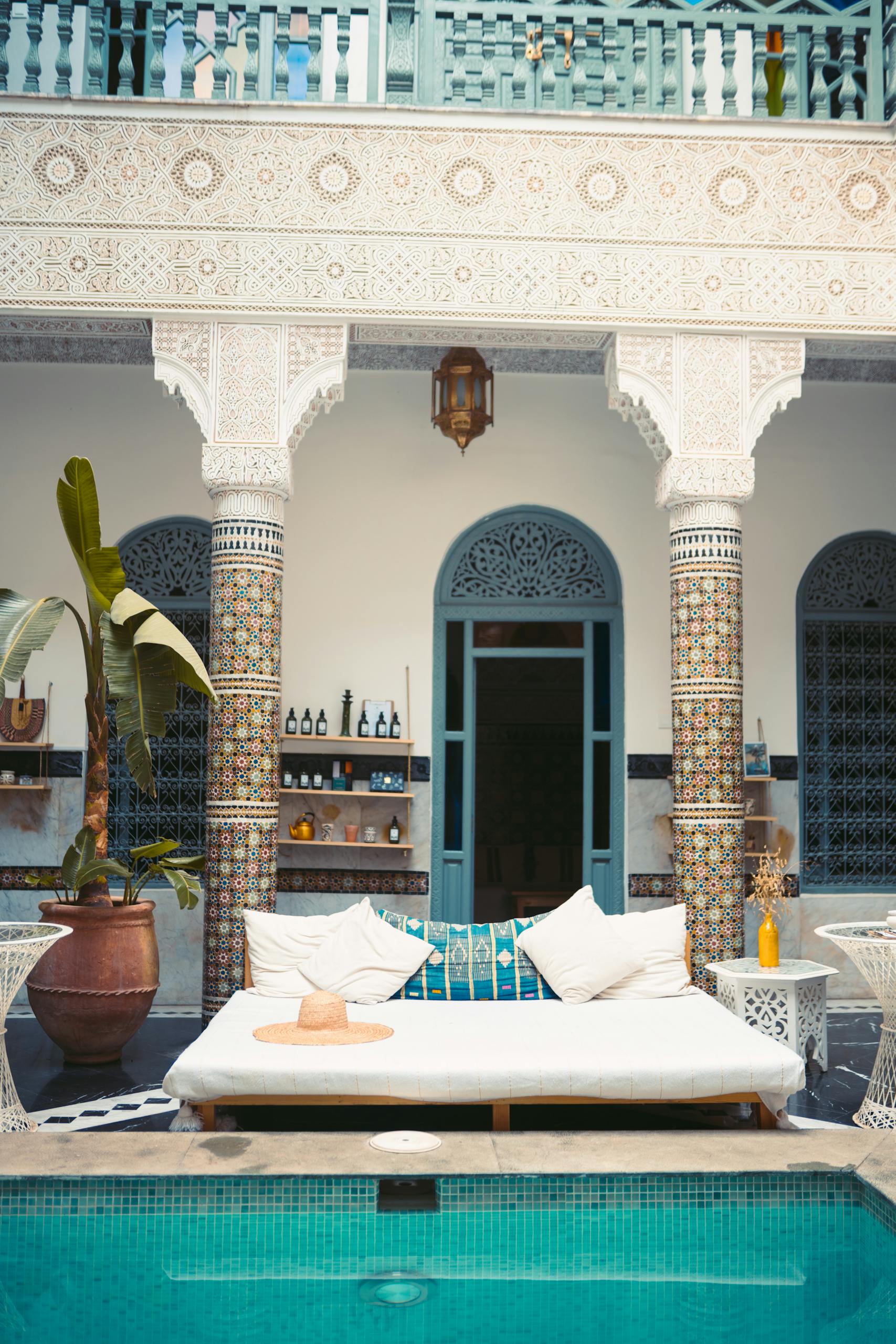 Elegant Moroccan courtyard featuring a luxurious pool and traditional decor.